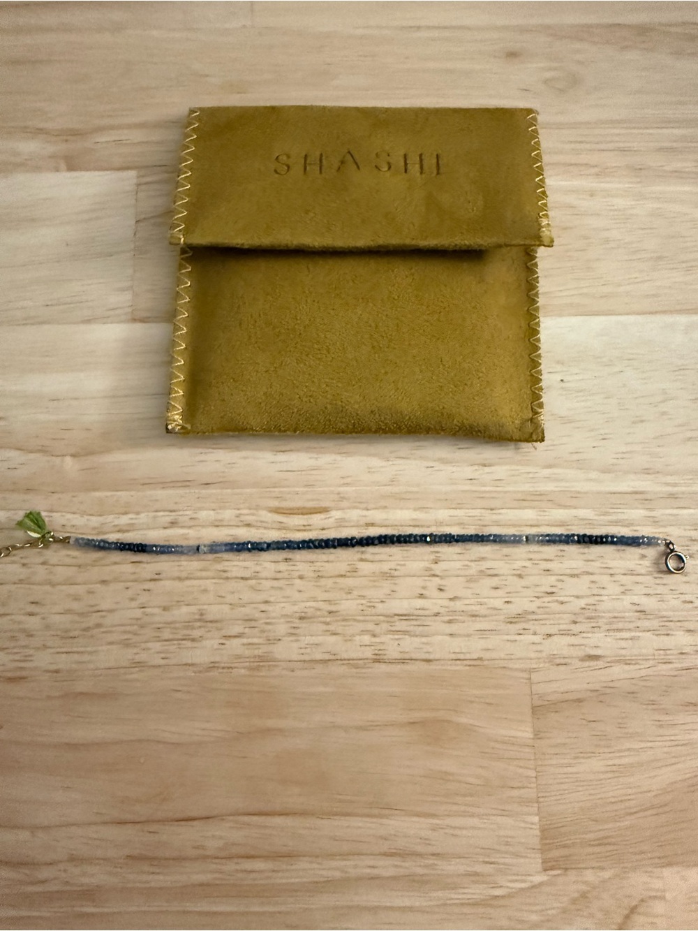 SHASHI Gold-Tone Bracelet with Blue Beads and Green Tassel